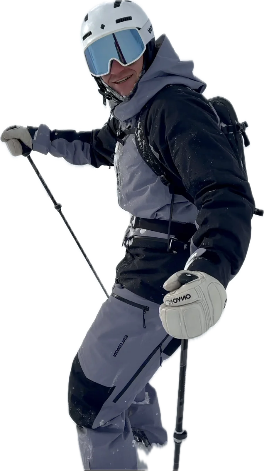 Adschi in Skibekleidung mit Helm, Skibrille und Stöcken